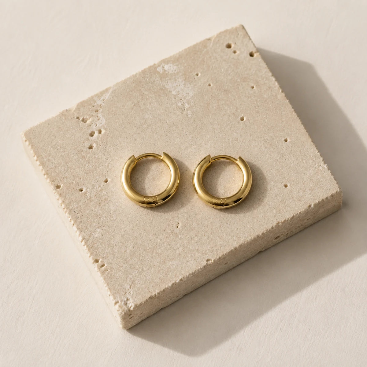 14K Huggie Hoops — top-down flat lay view